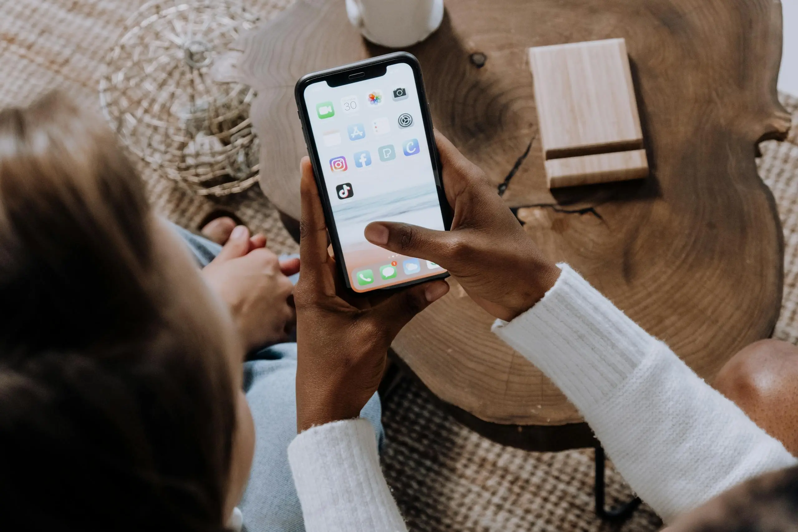 a person using a smartphone with social media apps sitting at a wooden table. perfect for tech lifestyle content. 5081926 scaled A person using a smartphone with social media apps, sitting at a wooden table. Perfect for tech lifestyle content.