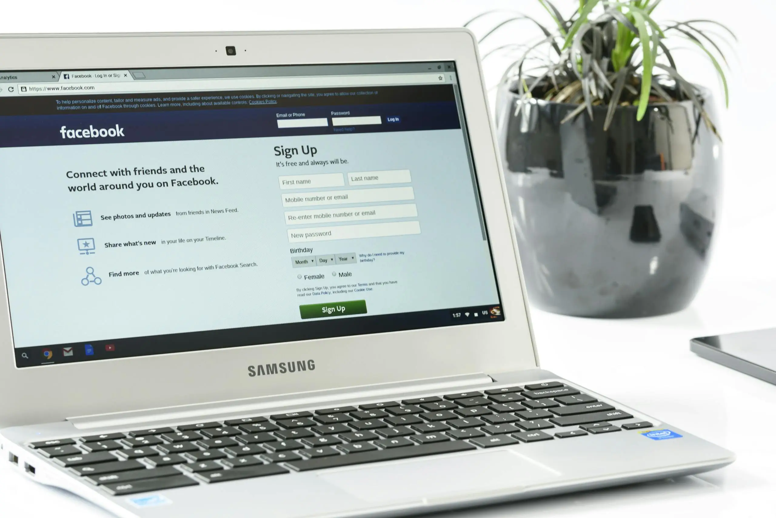 open samsung laptop showing facebook sign up page next to a potted plant. ideal for technology themes. 162622 scaled Open Samsung laptop showing Facebook sign-up page next to a potted plant. Ideal for technology themes.